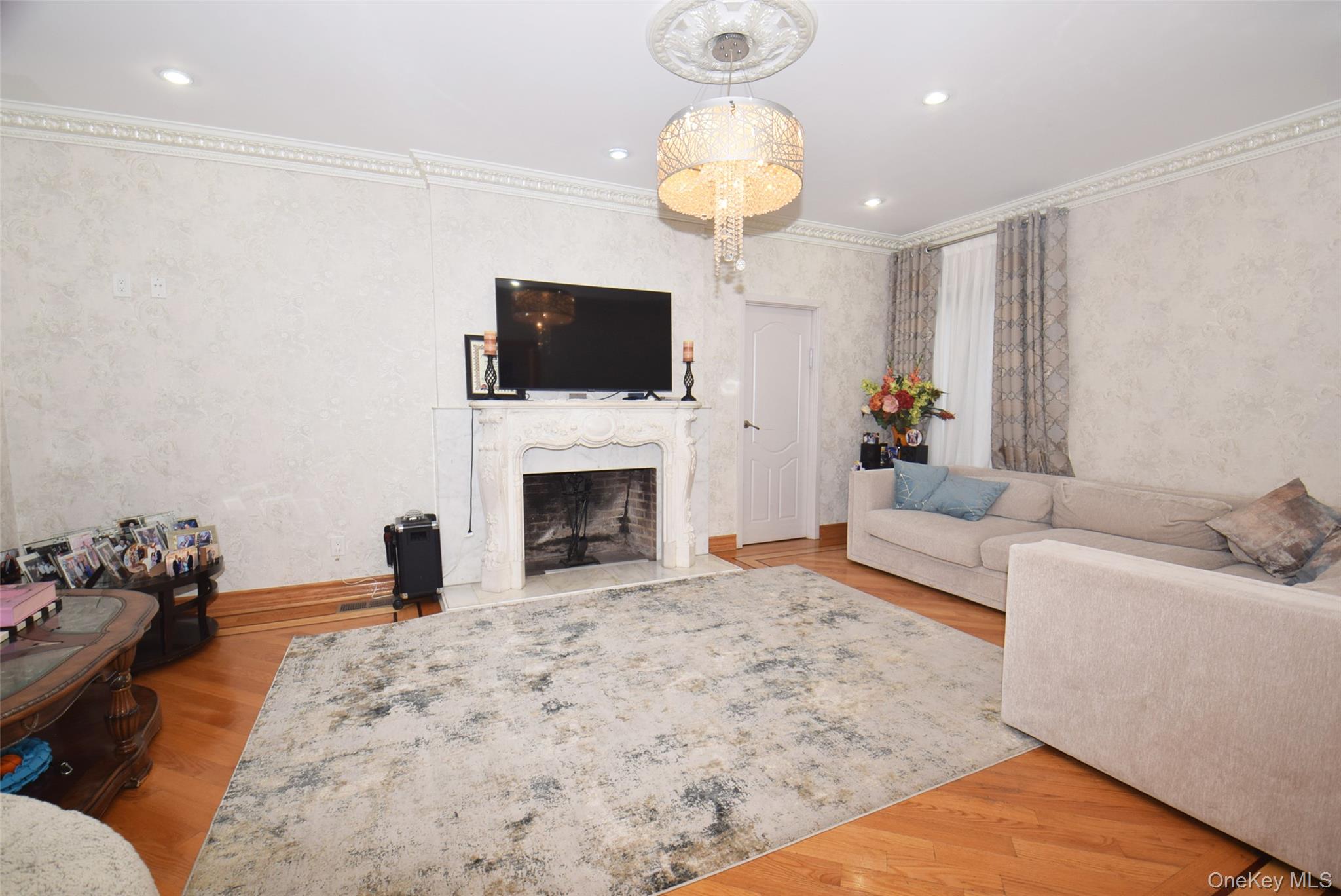 1-10 82nd Avenue Queens, NY 11415 - Photo 8 of 50 a living room with furniture a fireplace and a flat screen tv