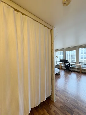 a view of a room with a window and wooden floor