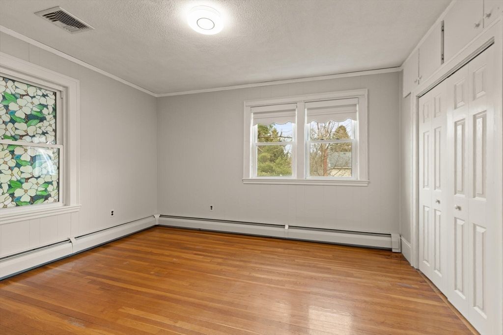 59 Reed Street Lexington, MA 02421 - Photo 20 of 32 an empty room with wooden floor and windows