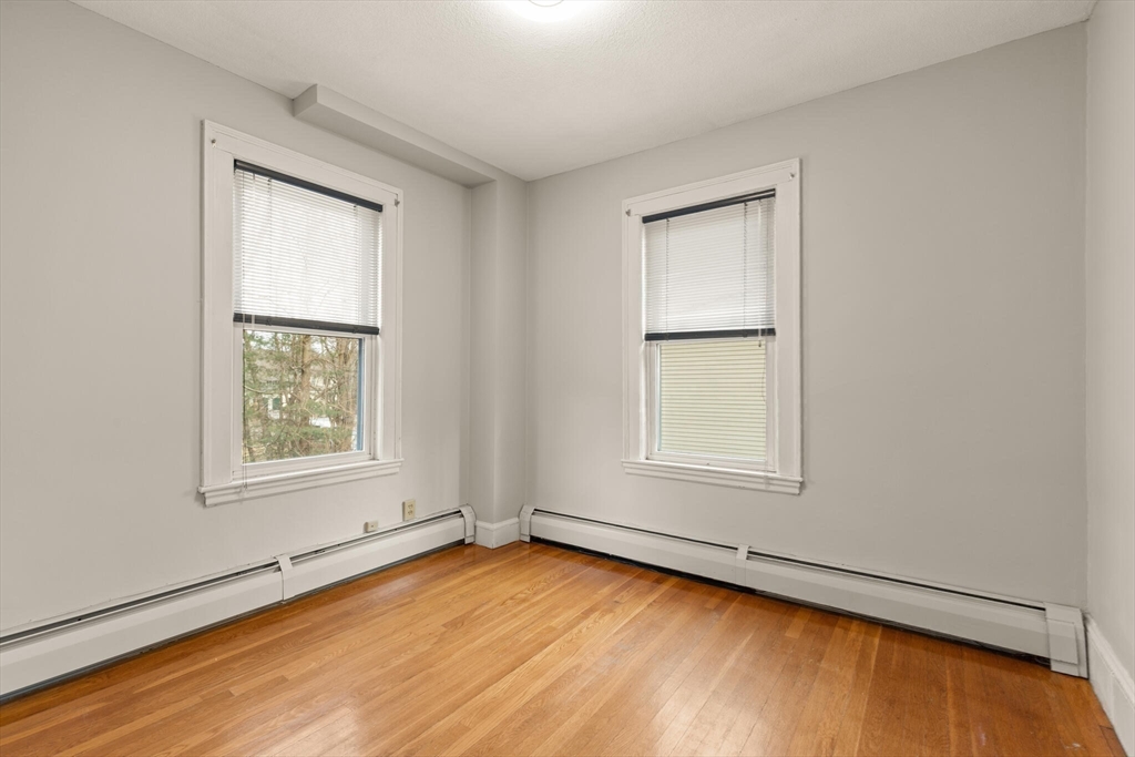 59 Reed Street Lexington, MA 02421 - Photo 21 of 32 an empty room with wooden floor and windows