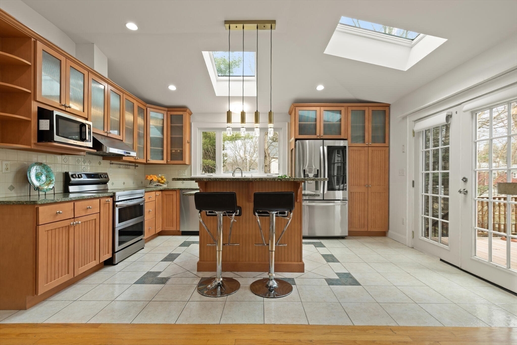 59 Reed Street Lexington, MA 02421 - Photo 4 of 32 a kitchen with stainless steel appliances granite countertop a stove a sink dishwasher a refrigerator and cabinets with wooden floor