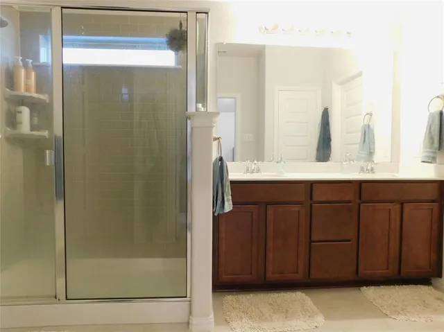a spacious bathroom with a sink a mirror and shower