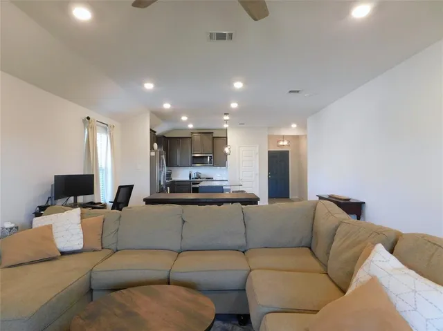 a living room with a couch and a view of kitchen