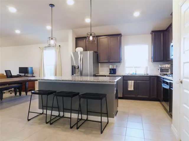 a kitchen with a refrigerator a sink and chairs