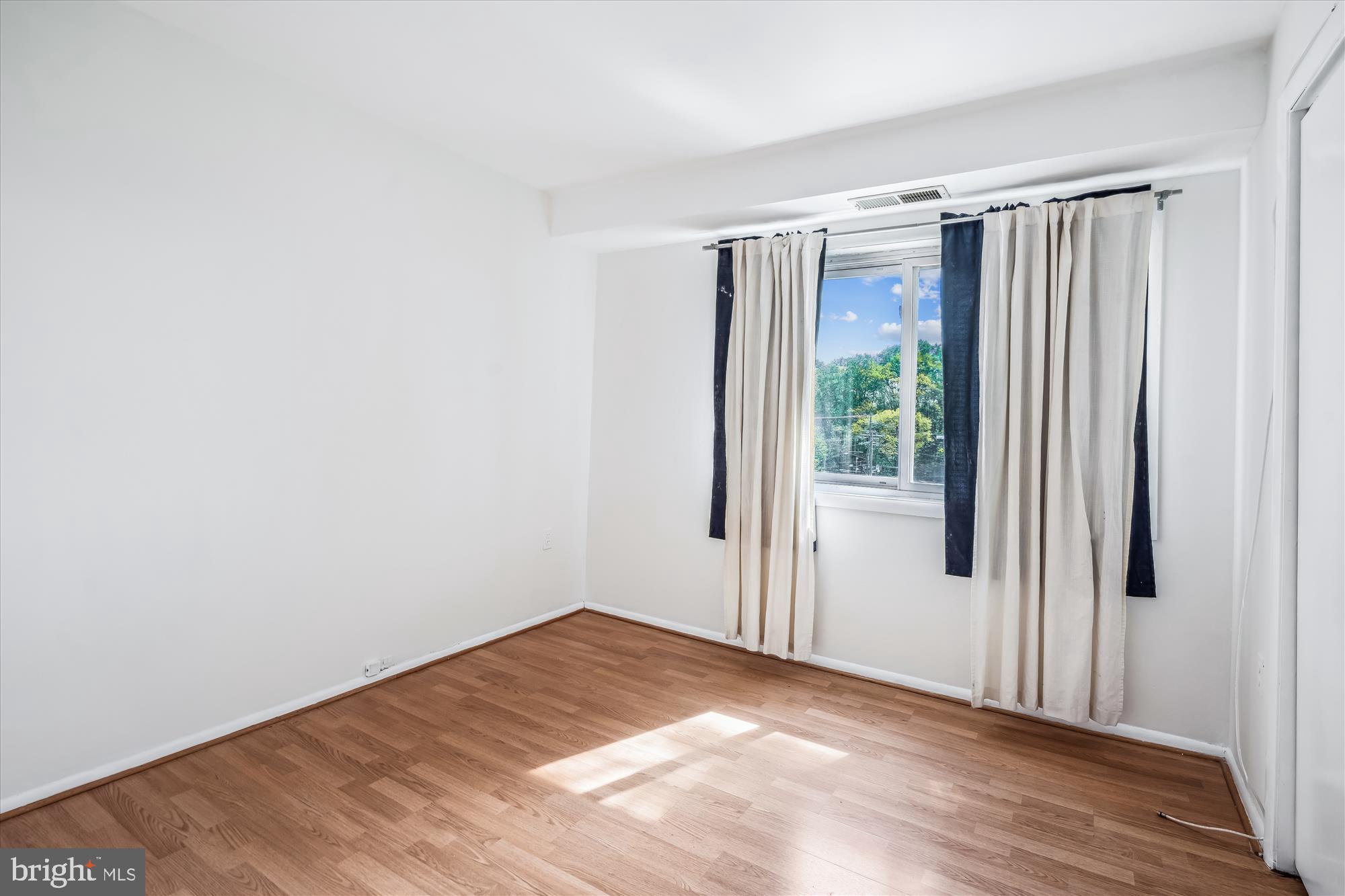 9274 Adelphi Road, Unit 202 Hyattsville, MD 20783 - Photo 12 of 25 a view of empty room with wooden floor and fan