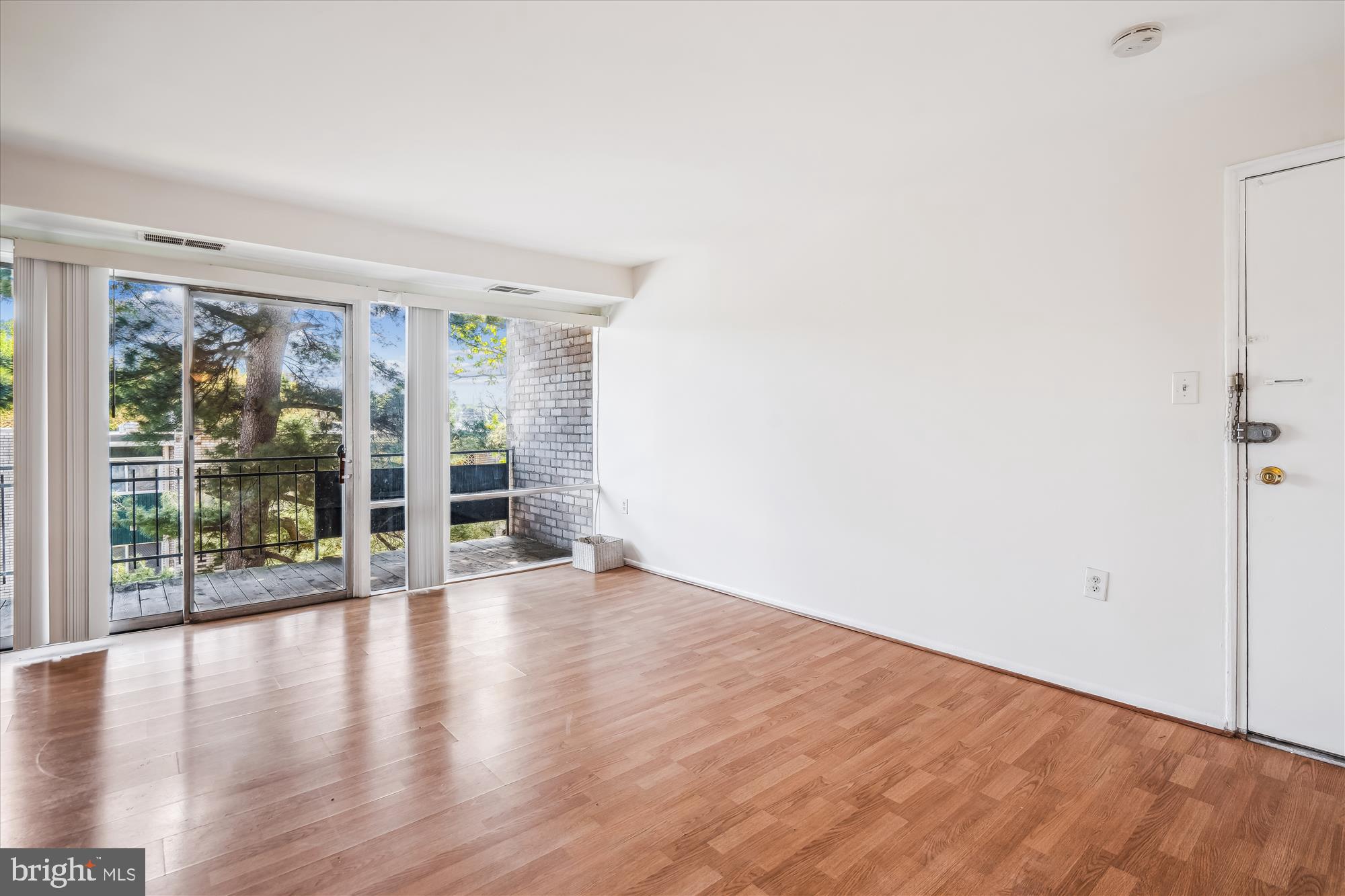 9274 Adelphi Road, Unit 202 Hyattsville, MD 20783 - Photo 17 of 25 an empty room with wooden floor and windows