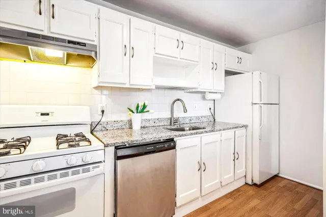 a kitchen with stainless steel appliances granite countertop a sink and a stove