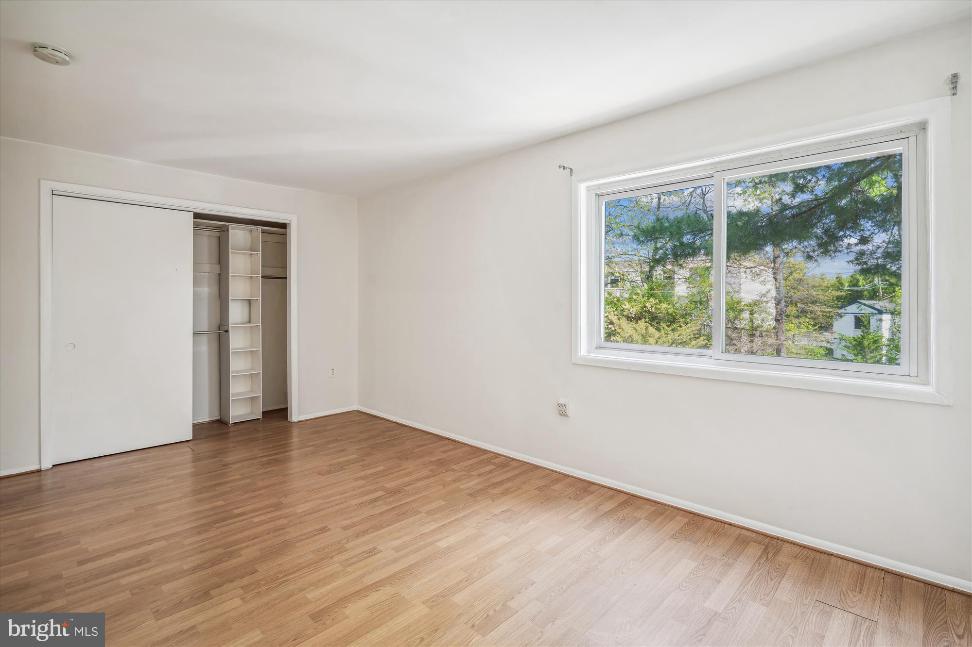 9274 Adelphi Road, Unit 202 Hyattsville, MD 20783 - Photo 9 of 25 an empty room with wooden floor and windows