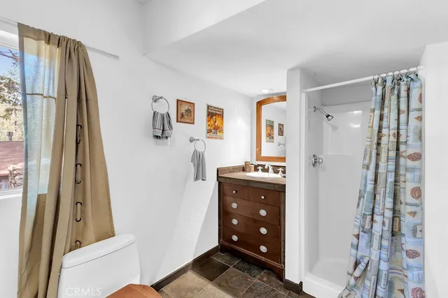 a walk in closet with wooden floor