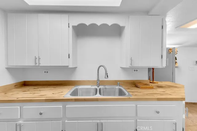 a kitchen with granite countertop white cabinets and a sink