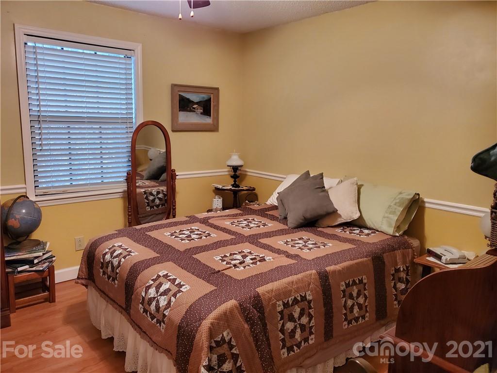 1856 Wesley Road Morganton, NC 28655 - Photo 2 of 7 a bedroom with a bed and a chandelier