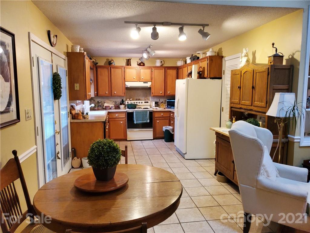 1856 Wesley Road Morganton, NC 28655 - Photo 3 of 7 a view of a dining room with furniture a kitchen and chandelier