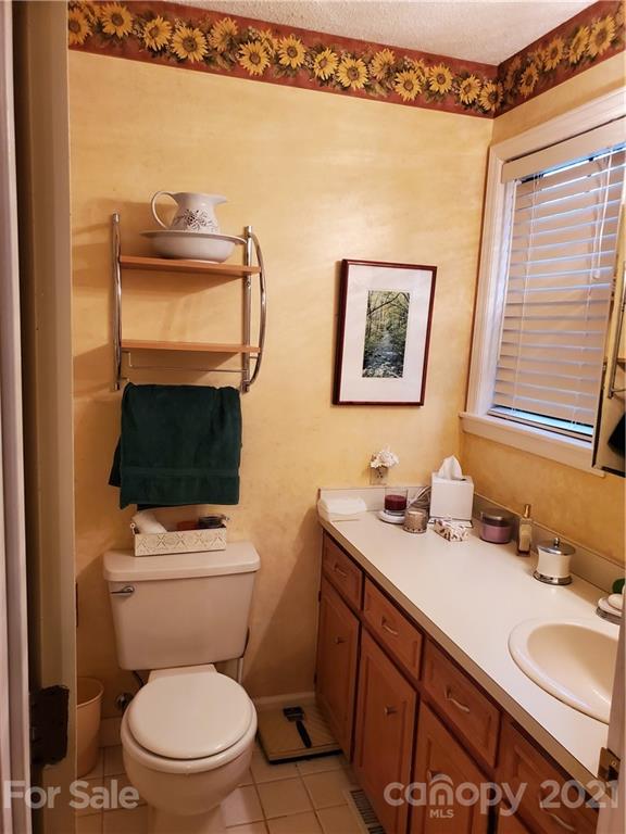 1856 Wesley Road Morganton, NC 28655 - Photo 6 of 7 a bathroom with a toilet a sink and mirror