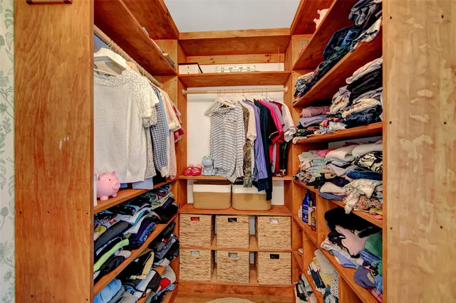 a view of walk in closet with clothes and shoes