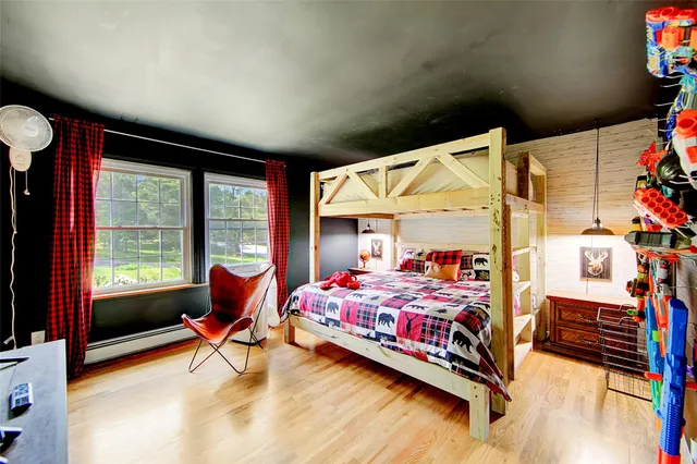 a bedroom with a bed and wooden floor