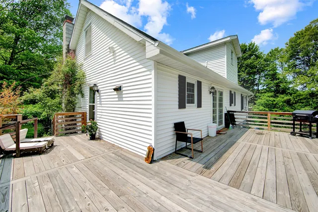 a view of a house with barbeque and wooden floor