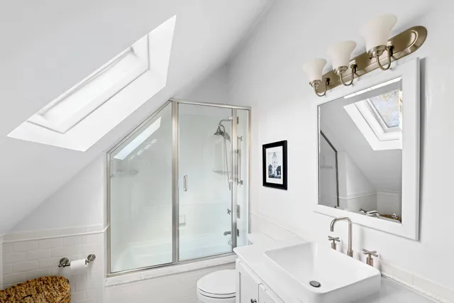 a bathroom with a sink and mirror with bathtub