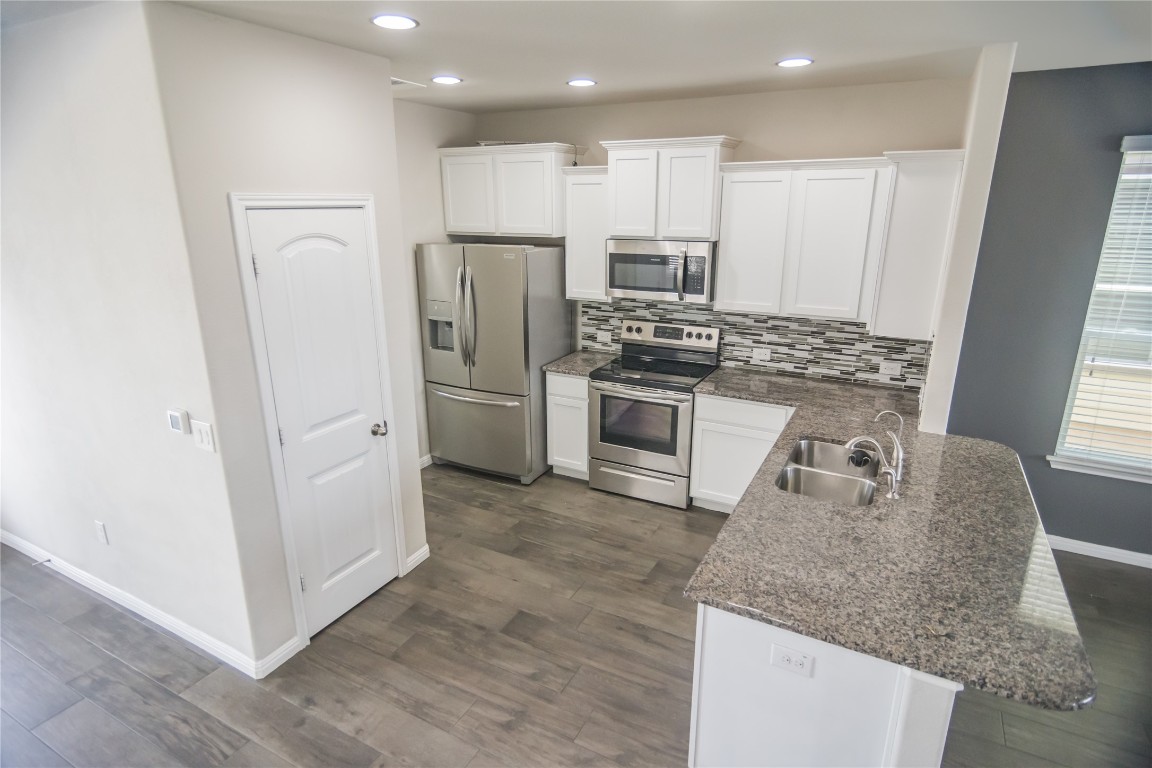 332 Cane River Road Pflugerville, TX 78660 - Photo 23 of 30 a kitchen with stainless steel appliances granite countertop a refrigerator sink and stove