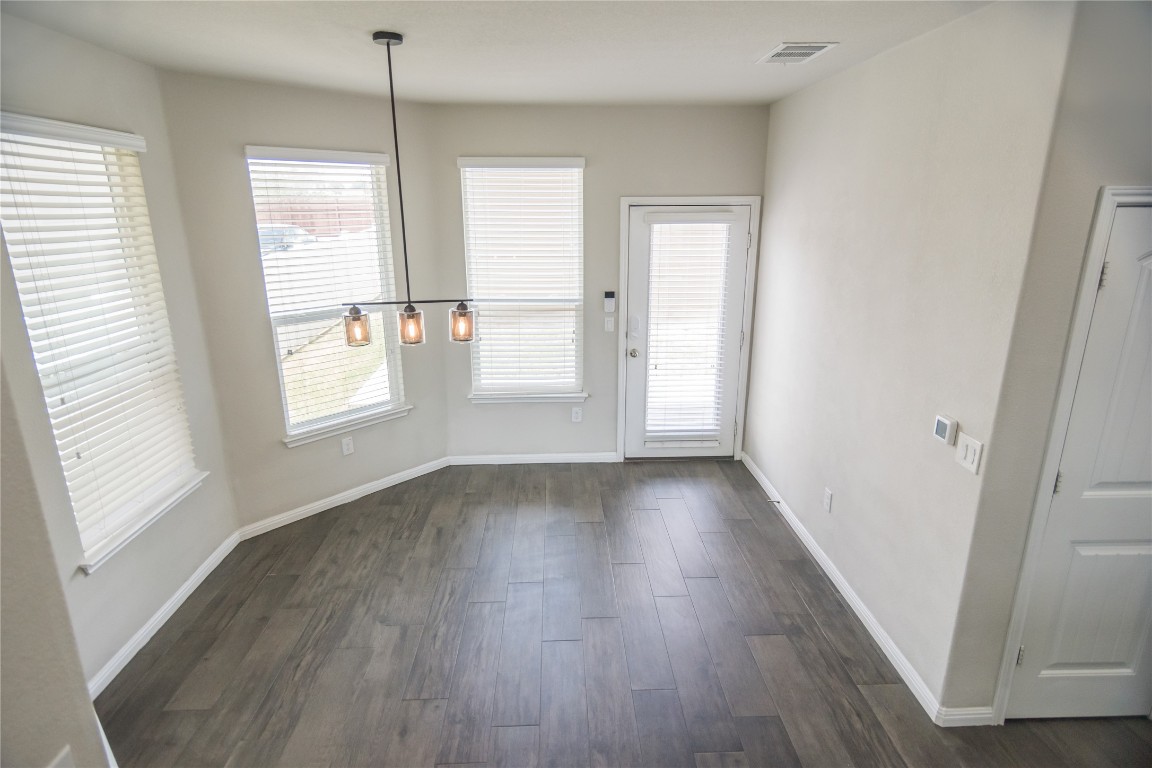 332 Cane River Road Pflugerville, TX 78660 - Photo 25 of 30 a view of an empty room with wooden floor and a window