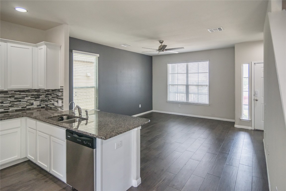 332 Cane River Road Pflugerville, TX 78660 - Photo 6 of 30 a kitchen with granite countertop white cabinets and a wooden floor