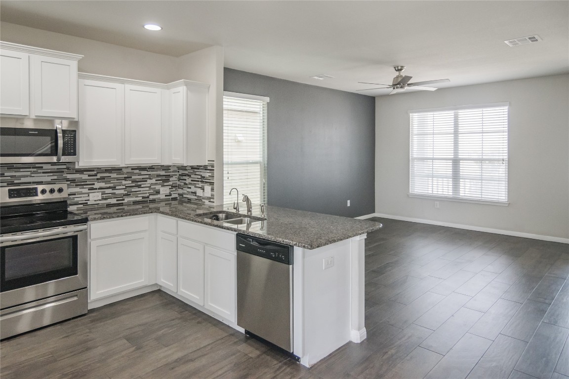 332 Cane River Road Pflugerville, TX 78660 - Photo 9 of 30 a kitchen with stainless steel appliances granite countertop a stove and a sink