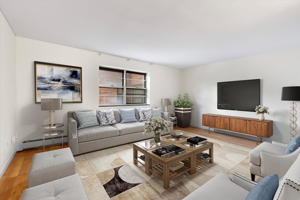 a living room with furniture a flat screen tv and a window