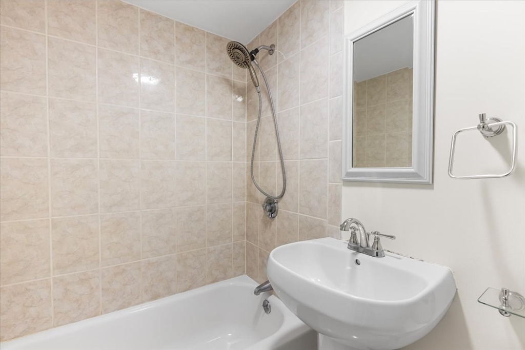 4925 Washington Street, Unit 304 Boston, MA 02132 - Photo 12 of 25 a bathroom with a sink a toilet and shower