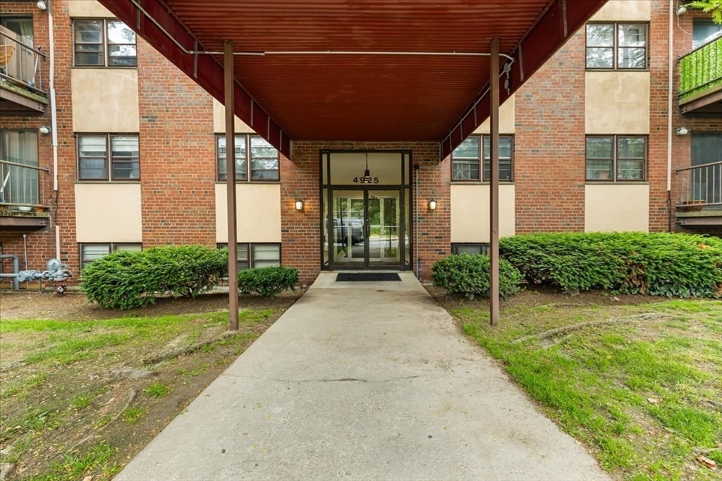 4925 Washington Street, Unit 304 Boston, MA 02132 - Photo 17 of 25 a view of a patio with table and chairs and potted plants
