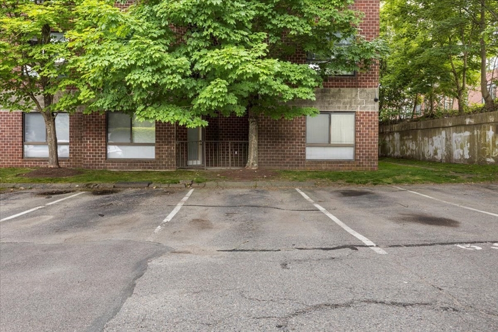 4925 Washington Street, Unit 304 Boston, MA 02132 - Photo 22 of 25 front view of a house with a yard and an trees