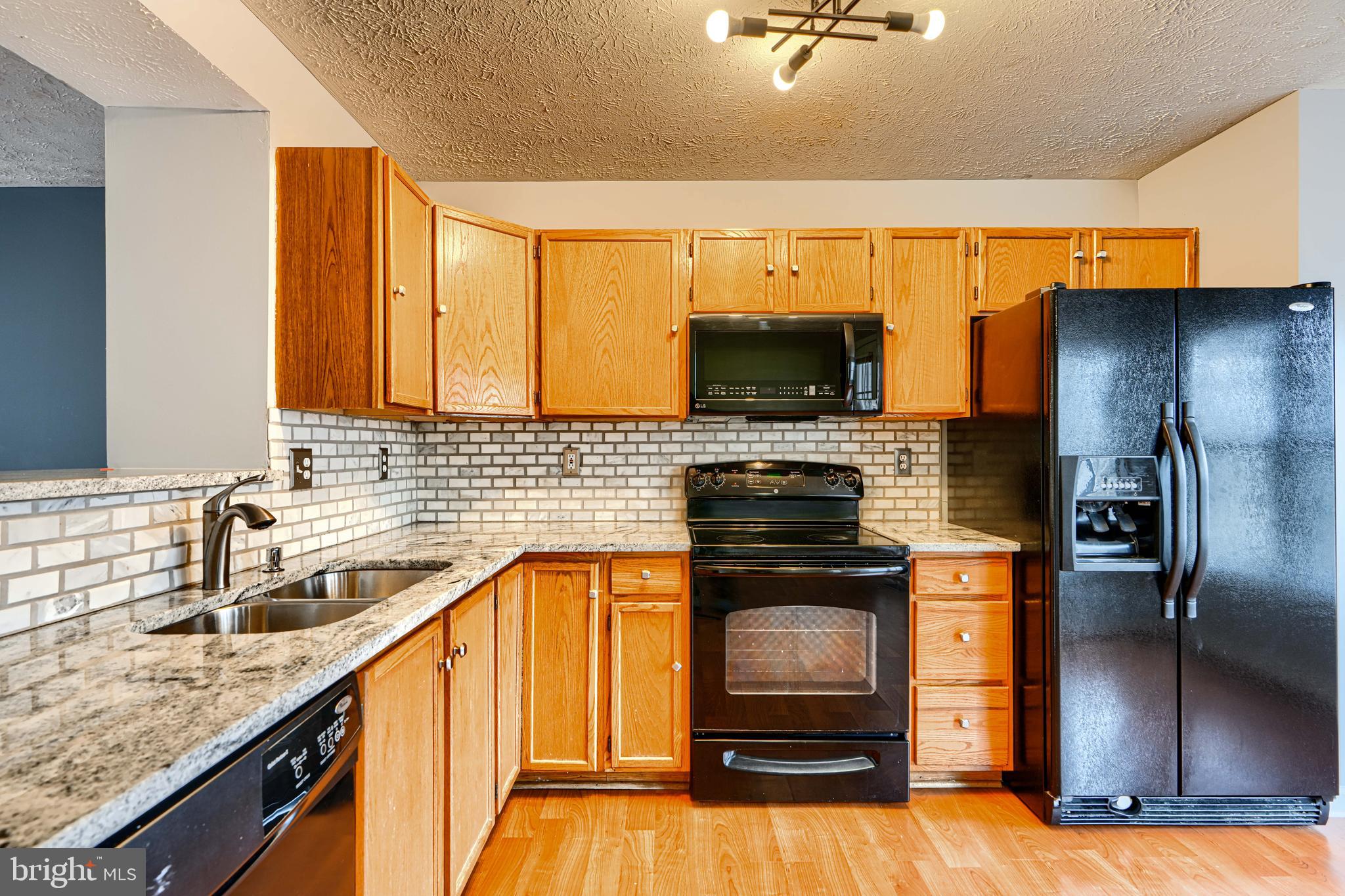 62 Gwynnswood Road Owings Mills, MD 21117 - Photo 13 of 44 a kitchen with stainless steel appliances granite countertop a sink a stove and a refrigerator
