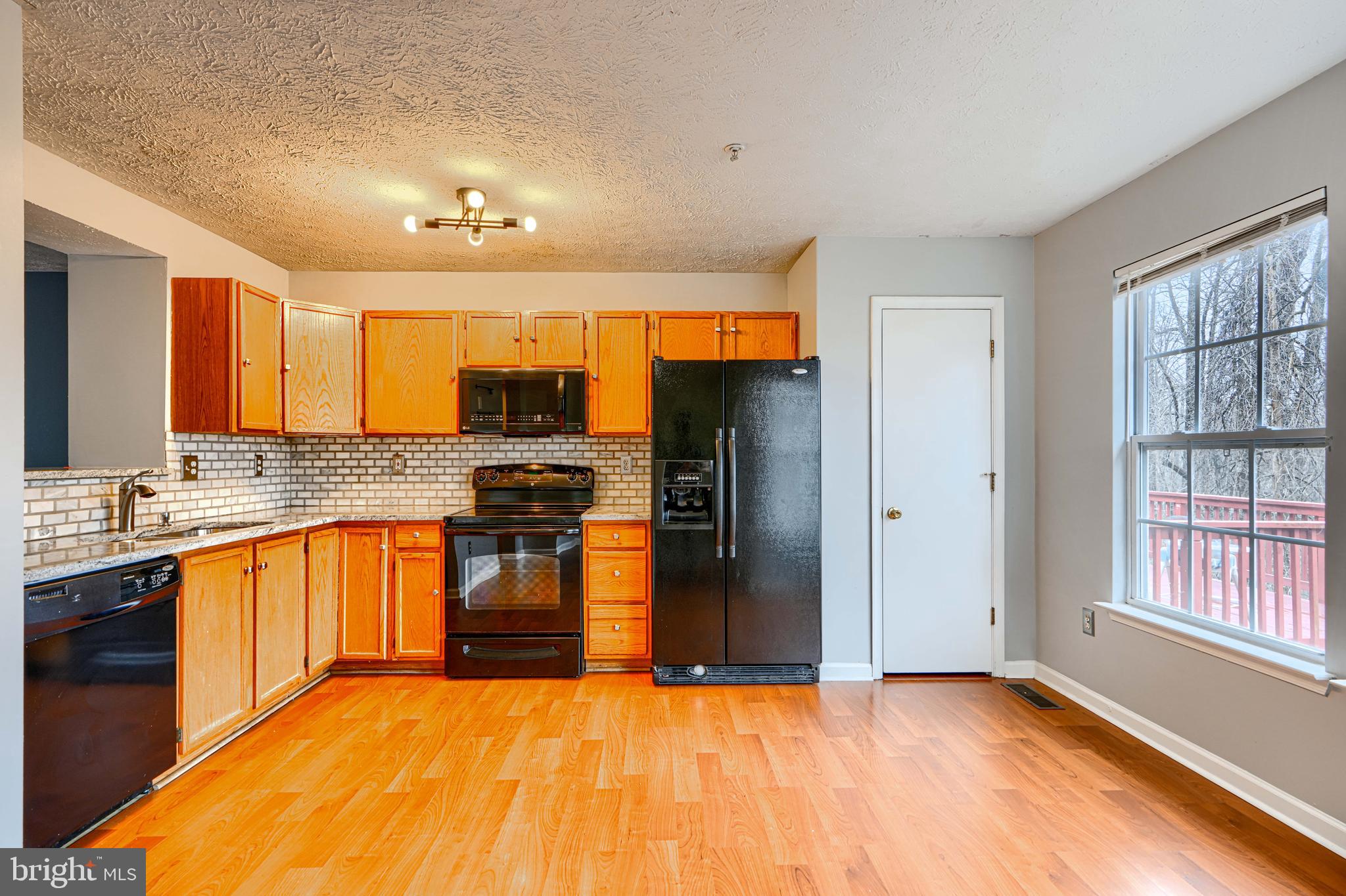 62 Gwynnswood Road Owings Mills, MD 21117 - Photo 14 of 44 a large kitchen with granite countertop a refrigerator and a stove top oven