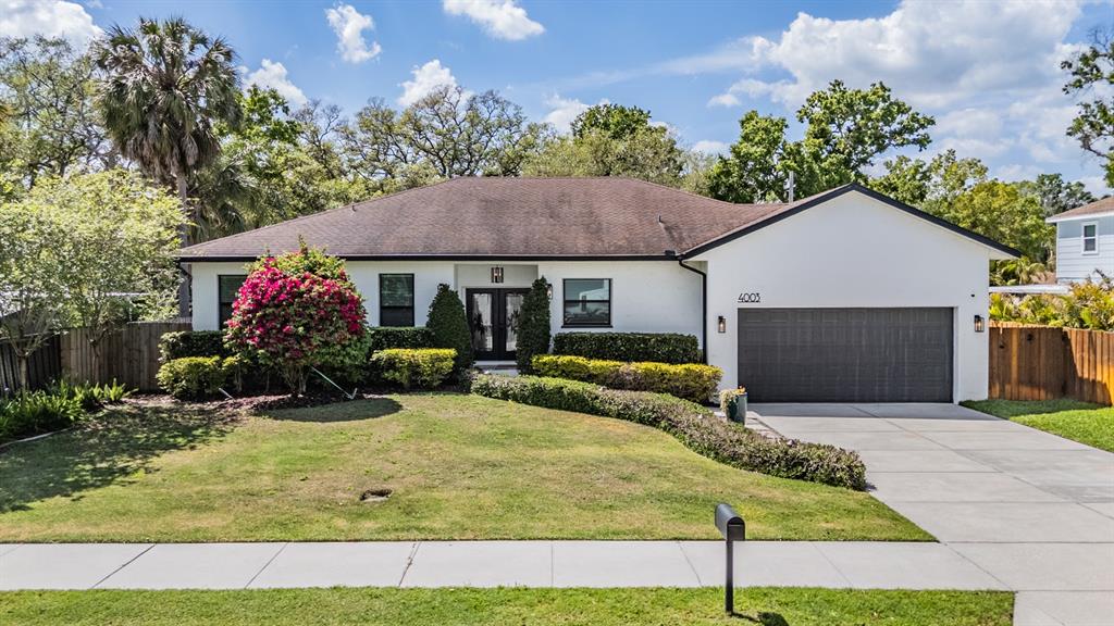 a front view of house with yard and trees in the background