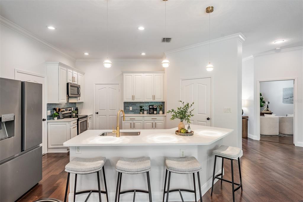 4003 South Shamrock Road Tampa, FL 33611 - Photo 13 of 38 a kitchen with stainless steel appliances kitchen island granite countertop a kitchen island and chairs in it