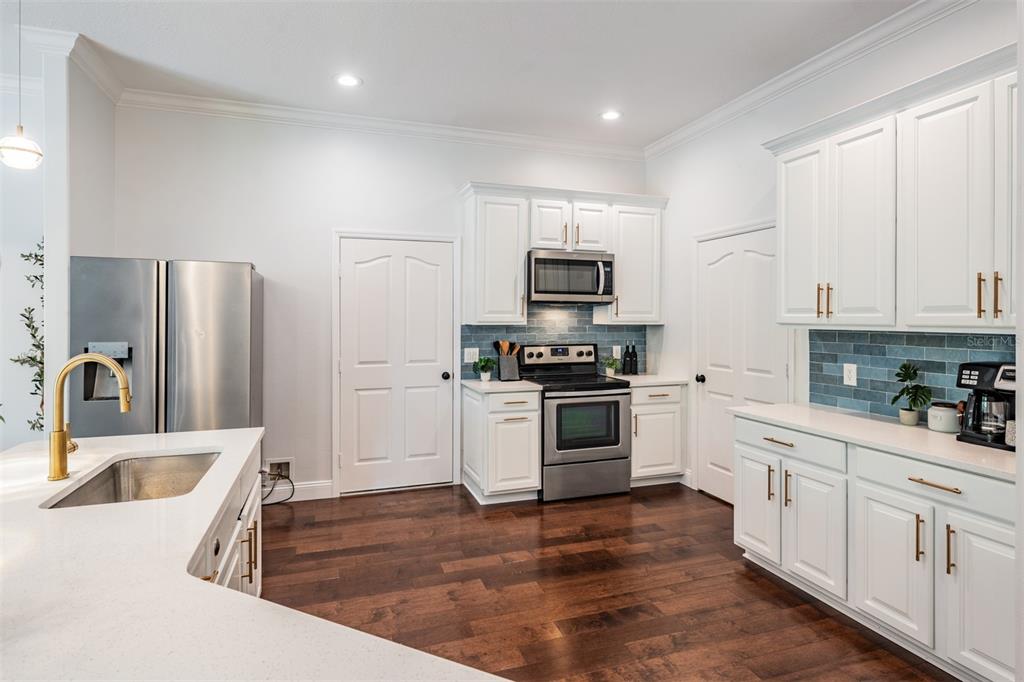 4003 South Shamrock Road Tampa, FL 33611 - Photo 15 of 38 a kitchen with white cabinets and stainless steel appliances