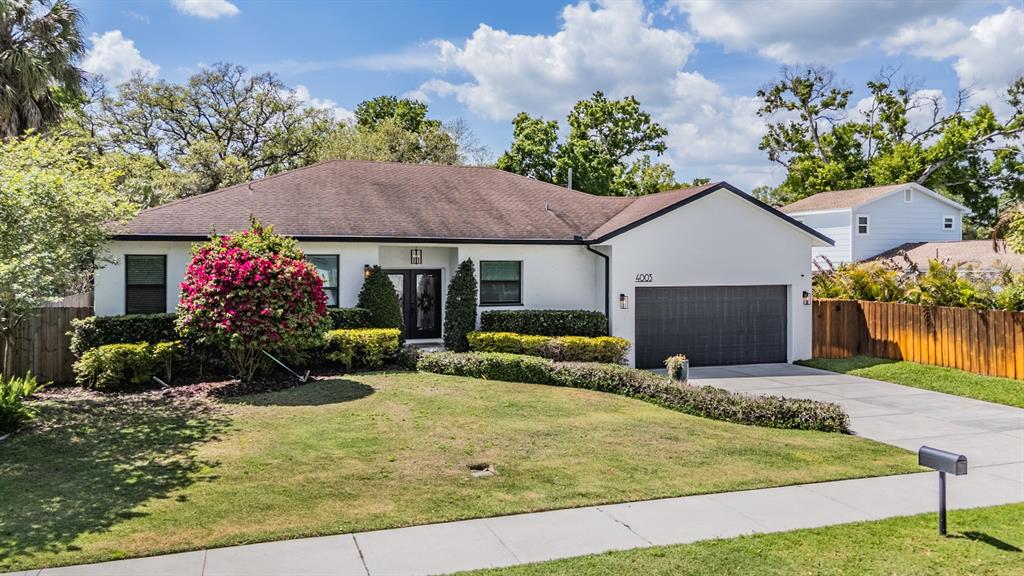 4003 South Shamrock Road Tampa, FL 33611 - Photo 2 of 38 a front view of house with yard and trees in the background