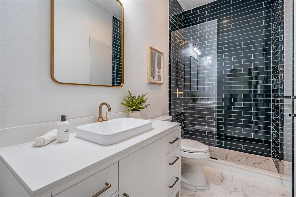 4003 South Shamrock Road Tampa, FL 33611 - Photo 27 of 38 a bathroom with a sink a toilet and shower
