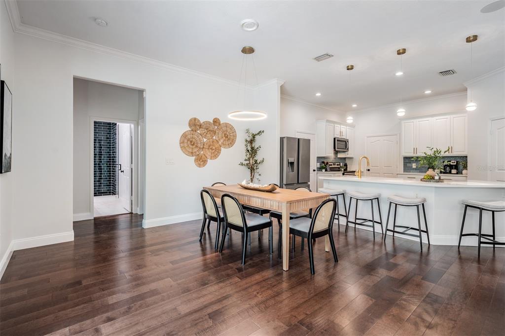 4003 South Shamrock Road Tampa, FL 33611 - Photo 10 of 38 a dining area with furniture a kitchen view and wooden floor