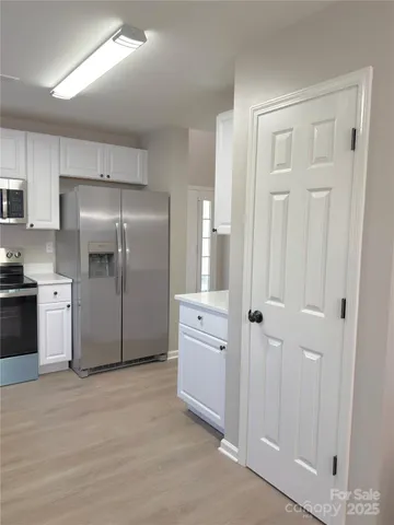 a kitchen with white cabinets and stainless steel appliances