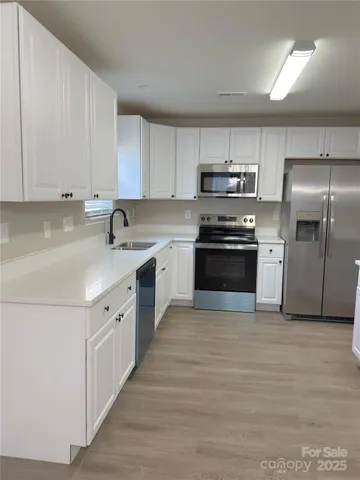 a kitchen with stainless steel appliances granite countertop a sink and a stove