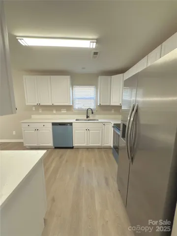 a kitchen with stainless steel appliances a refrigerator sink and cabinets