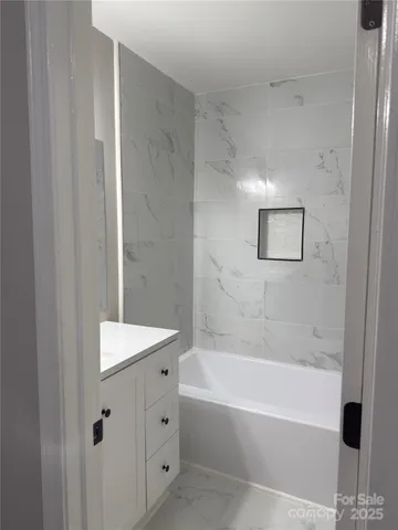 a bathroom with a bathtub a shower and a sink