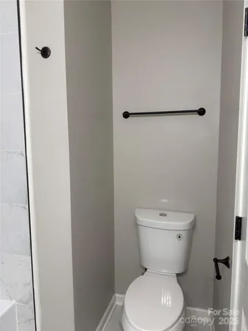 a white toilet sitting next to a shower