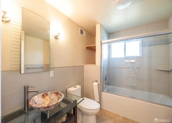 a bathroom with a sink a toilet a mirror and bathtub