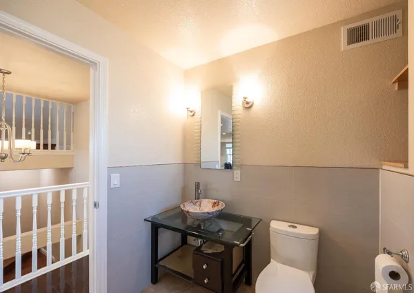 a bathroom with a sink a toilet and a mirror