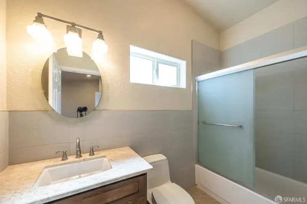 a bathroom with a sink a mirror a toilet and vanity