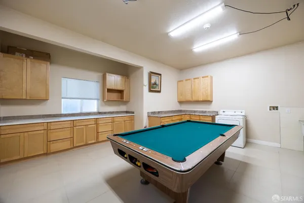 a room with pool table and windows
