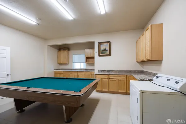 a room with pool table and windows