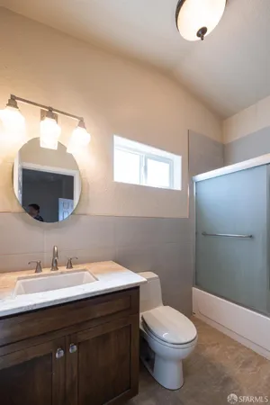 a bathroom with a granite countertop toilet sink and mirror