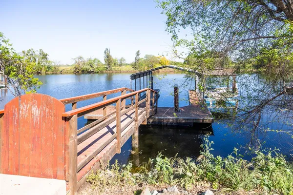 a view of a house with pool and chairs next to a yard