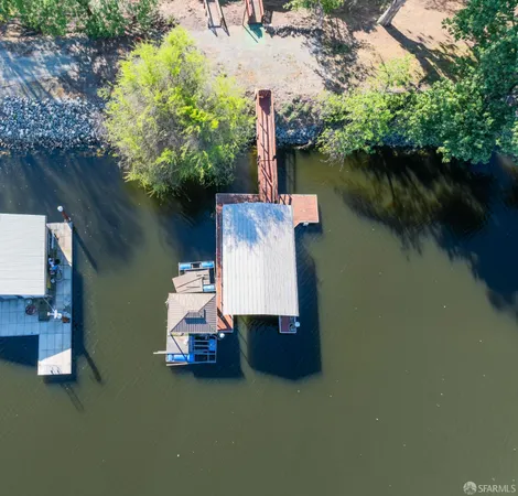 an aerial view of a house with a garden and lake view